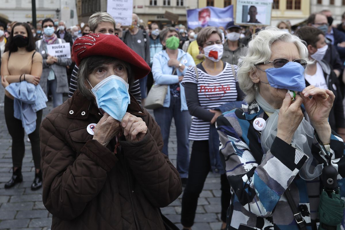 Elderly women wearing face masks to protect against coronavirus, blow whistles, during a protest at the Old Town Square in Prague, Czech Republic, Tuesday, June 9, 2020. Hundreds of people protested in the Czech capital to draw attention to the government