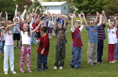 
Sunrise Elementary School second-graders who were in Eric Kramer's class at the start of the school year wave to an airplane from their position at the school on Tuesday. Kramer, an Army reservist, was deployed to Afghanistan in April. 
 (Liz Kishimoto / The Spokesman-Review)