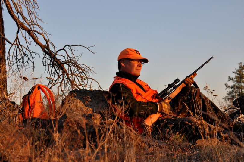 Adam Lynn of Tacoma greets the Oct. 13, 2013, sunrise from his deer hunting position in the scablands of Lincoln County. (Rich Landers)