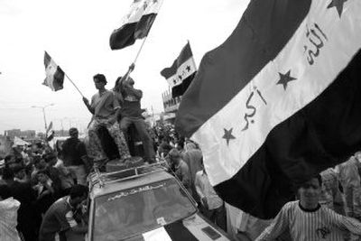 
People wave national flags during a protest in Baghdad on Saturday. Some 1,500 people demanded that the government make the streets of Baghdad safer. 
 (Associated Press / The Spokesman-Review)