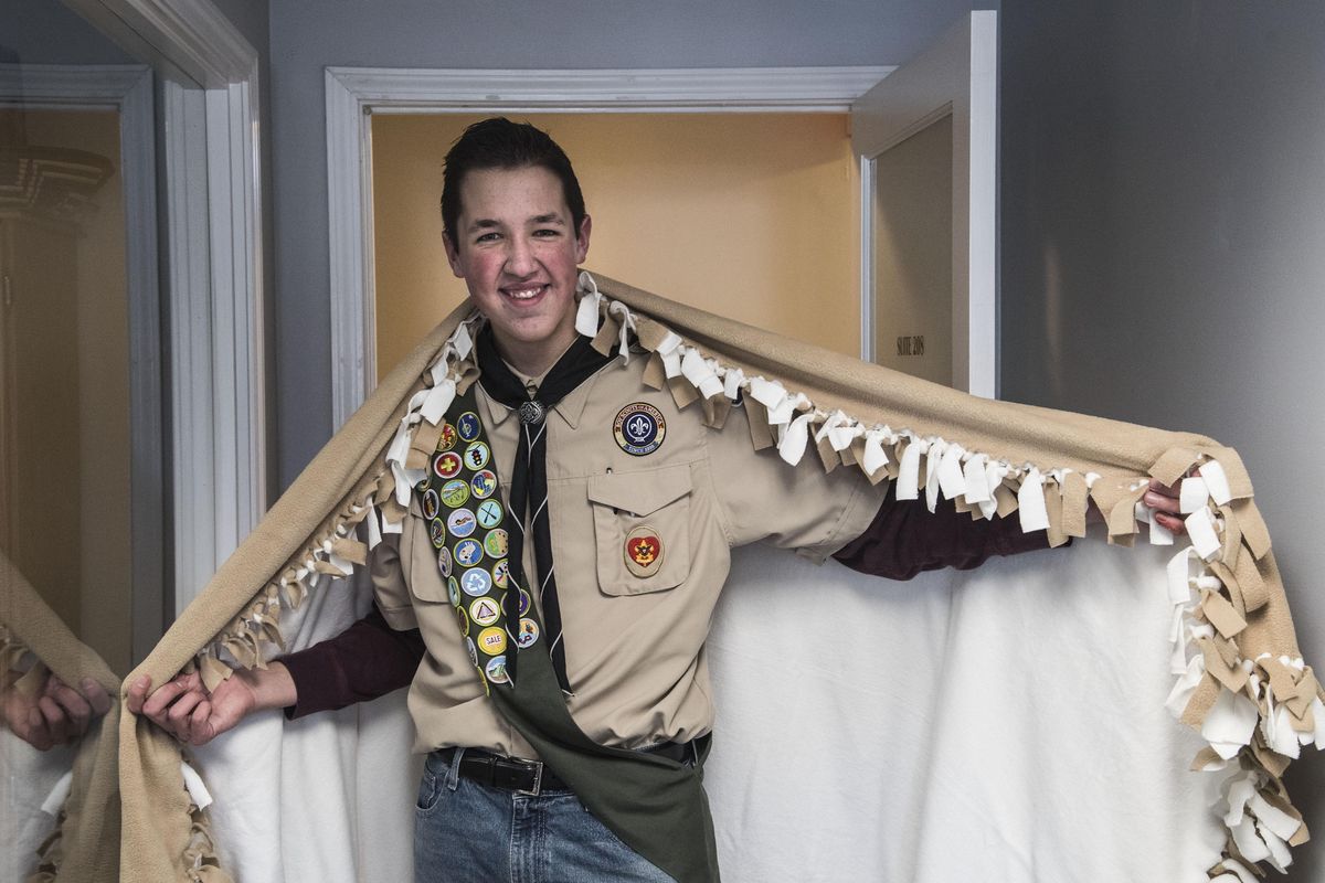 Boy Scout Jared Freedland shows one of the 15 blankets he had a hand in making. Freedland gathered and washed 335 blankets to give to World Relief Spokane for his Eagle Scout project. (Dan Pelle / The Spokesman-Review)