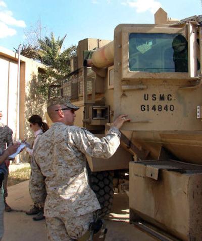 
Marines at Camp Falluja in Iraq point out blast marks on their Mine Resistant Ambush Protected vehicles (MRAPs) in this April 19 file photo. 
 (Associated Press / The Spokesman-Review)