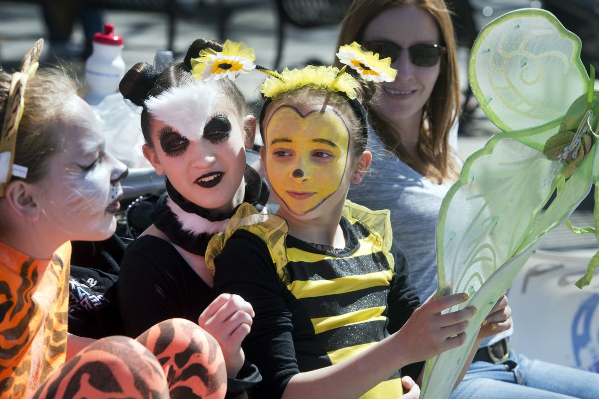 Spokane Aerial Performance Arts performers Reece Brickett, dressed as a tiger, Adlee Filbert, a panda, and Maya Meeks, a honeybee, take a break near the Rotary Fountain on Saturday.
