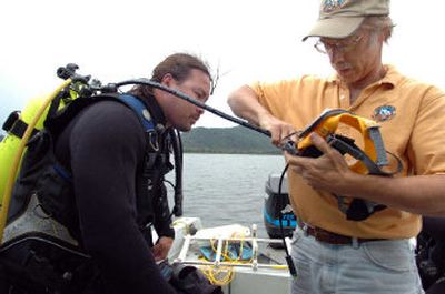 
Dave Lamb, lake ecologist for the Coeur d'Alene Tribe, helps diver Rich Curry prepare his face mask as the team seeks to map the spread of Eurasian milfoil on the southern third of Lake Coeur d'Alene. 
 (Photos by Jesse Tinsley / The Spokesman-Review)