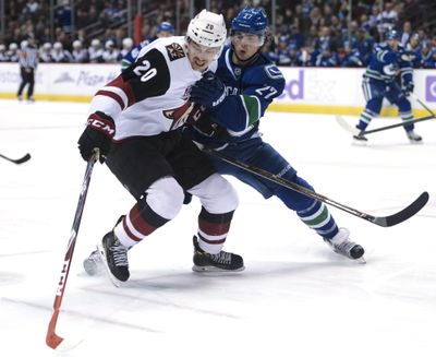 Vancouver Canucks defenseman Ben Hutton, right, fights for control of the puck with Arizona Coyotes center Dylan Strome during the first period of an NHL hockey game Thursday, Nov. 17, 2016, in Vancouver, British Columbia. (Jonathan Hayward / Associated Press)