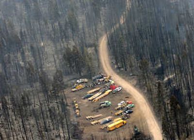 
Firefighters and trucks stage in a burned-over area of the Jocko Lakes fire near Seeley Lake, Mont., on Tuesday. Associated Press
 (Associated Press / The Spokesman-Review)