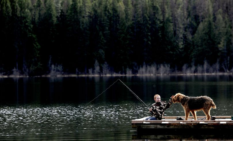 Waiting for a bite: “I want to catch anything that’ll bite,” said Kaden Thompson, 9, of Sandpoint, as he fished at Round Lake in Dufort, Idaho, with his friend’s dog Athena on Monday. (Kathy Plonka)