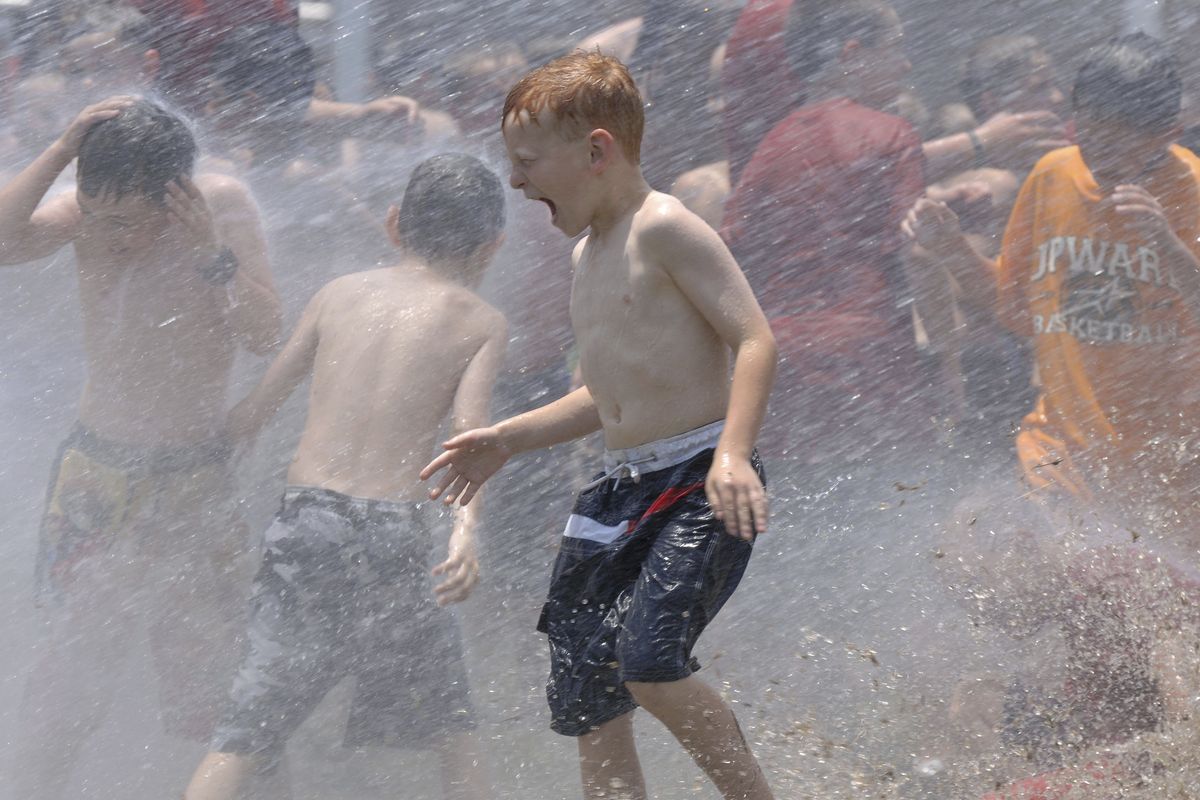 In this June 9, 2006 photo, kids from a day camp get soaked by the the fire department at Tyler Junior College in Tyler, Texas. The U.S. has seen a string of COVID-19 outbreaks tied to summer camps in recent weeks in Texas, Illinois, Florida, Missouri and Kansas, offering what some fear could be a preview of the upcoming school year.  (Brad Smith)