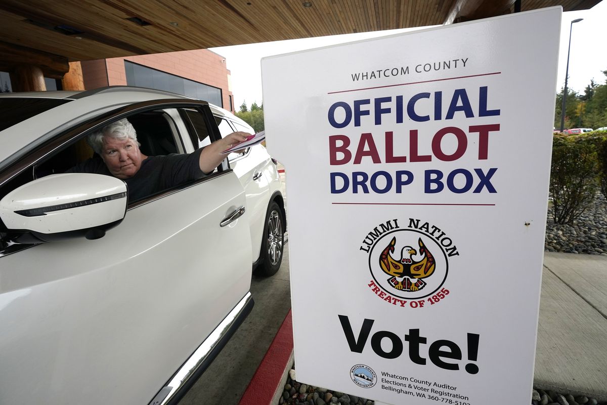 Lesley Beckley drops her completed ballot into a ballot drop box Monday, Oct. 19, 2020, on the Lummi Reservation, near Bellingham, Wash. Washington state is one of five states, along with Colorado, Hawaii, Oregon, and Utah, that conduct election entirely by mail-in voting.  (Elaine Thompson)