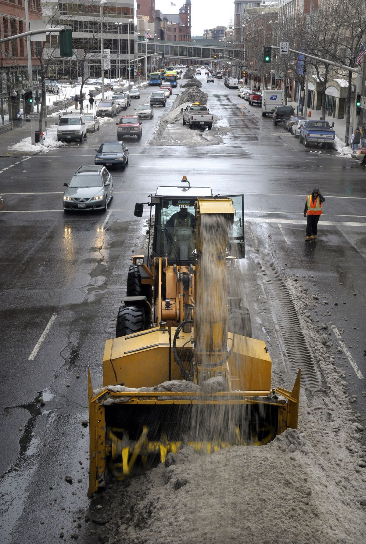 Crews knock down berms of snow and ice Wednesday on Riverside Avenue at Stevens Street in downtown Spokane.  (CHRISTOPHER ANDERSON / The Spokesman-Review)