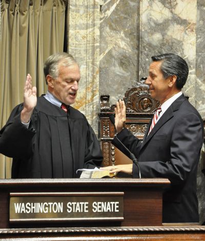 Filling in for the short term: Dino Rossi, right, a former state senator and candidate for governor and U.S. Senate, is sworn in Tuesday in Olympia to fill a state Senate seat in the 5th Legislative District. The seat opened when Sen. Cheryl Pflug resigned to accept an appointment to the Growth Management Hearings Board. Rossi will serve until the November general election. He can’t run for the seat because the boundary lines change for the new term. (Jim Camden)