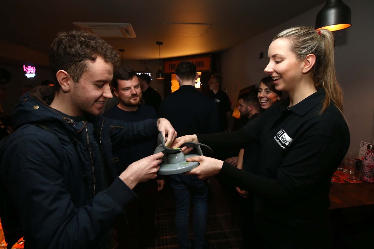A patron removes his phone from a Yondr pouch after a match during the GambleAware launch of the No BetInn Pub at the Head Of Steam on April 14, 2019, in Liverpool, England. The Numerica Veterans Arena will use the Yondr pouches to ensure a phone-free audience at the Ghost concert next week.  (Getty Images)