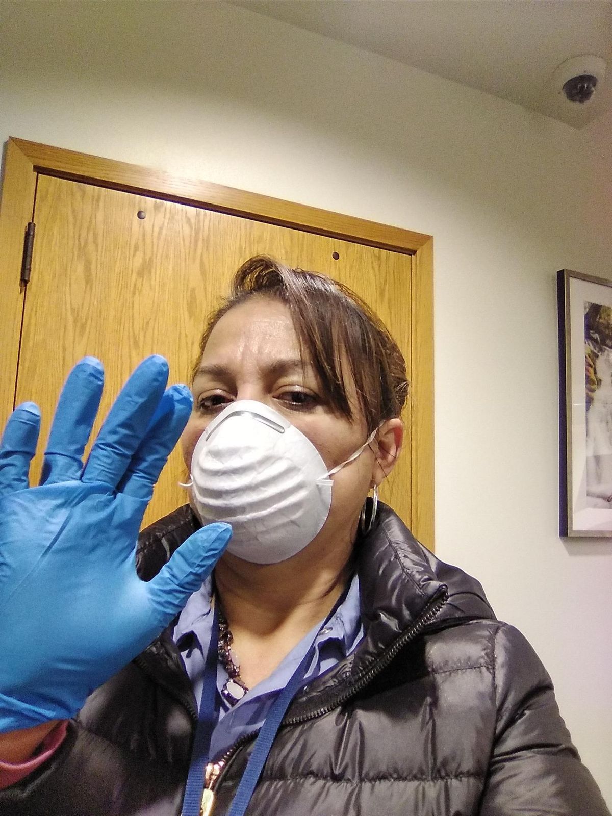 Guadalupe Peregrino shows the face mask and gloves she dons for her job wiping down surfaces at the Stemilt Growers Inc. packing plant in Wenatchee to prevent the spread of COVID-19. (Courtesy Guadalupe Peregrino)