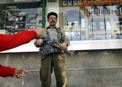 
An Afghan private security guard stands outside a shop in Kabul on Thursday. Afghan authorities this week shut down two private security companies and suggested more closures were coming. Associated Press
 (Associated Press / The Spokesman-Review)