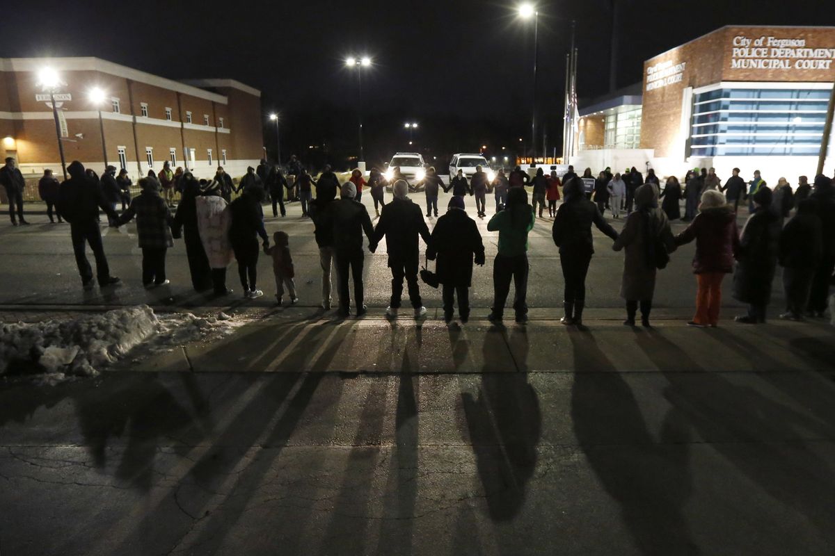 Protesters block traffic outside the Ferguson, Mo., police department Wednesday. (Associated Press)
