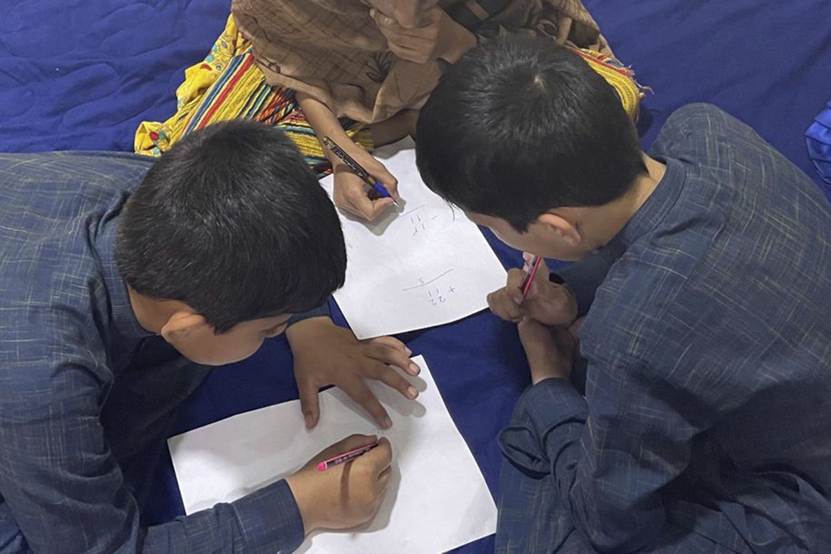 Three young children are seen studying in Afghanistan. Every night, their father, a U.S. green card holder from California, and his wife take turns sleeping, with one always awake to watch over the children so they can flee if they hear the footsteps of the Taliban. (HONS)