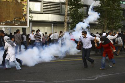 This photo taken by an individual not employed by the Associated Press  shows Iranian protesters running away from tear gas fired by security at  an opposition rally in Tehran, Iran, on Thursday.  (Associated Press / The Spokesman-Review)
