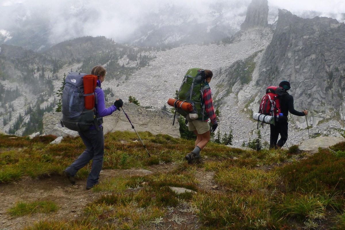 Lexi Greenwood, center, joins Kelly Kopczynski and her father, Chris Kopczynski, on a cross-country trek along the crest of the Idaho Selkirk Mountains. Chimney Rock is in the background. (Rich Landers / The Spokesman-Review)