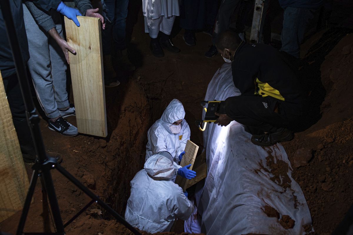 In this Sunday, June 27, 2021 photo, a Muslim burial of a COVID-19 victim takes place at the Westpark Cemetery in Johannesburg. Driven by the delta variant, a new wave of COVID-19 is sweeping across the African continent where new cases, hospital admissions, and deaths are increasing.  (Ali Greeff)