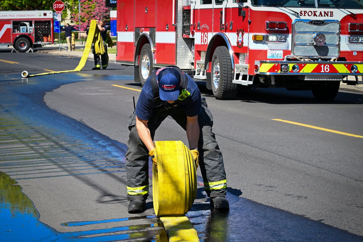 Finishing a job well done: Spokane County District 9 firefighter Erik Holm spent part of his 30th birthday Friday rolling fire hose on the scene of a car fire on the E 400 block of Rowan Avenue in Spokane. “It’s just part of the job,” he said.  (DAN PELLE/THE SPOKESMAN-REVIEW)