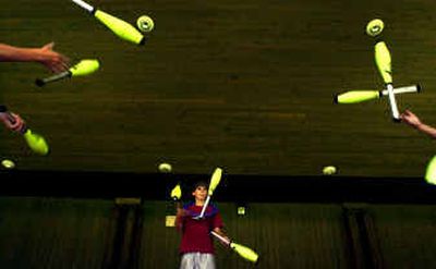 
Aidan Bennett, 12, practices a triangle juggling act with juggling clubs at the City Beach Rotary Bandshell on Monday with his teammates. They will perform Saturday at the juggling festival.
 (Jed Conklin / The Spokesman-Review)
