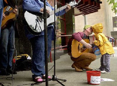 
For the love of charity – Benjamin Lyons, 4, kisses his dad, Jim, Tuesday afternoon in downtown Spokane while a group of musicians, including the Lyons duo – dad on guitar and Benjamin on drums – play to raise money for the Second Harvest Food Bank. 
 (Brian Plonka / The Spokesman-Review)