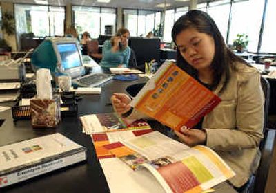 
Tracy Yen looks over 401(k) documents at her office in Los Gatos, Calif. After an experience with a previous employer, Yen initially opted to not participate in the 401(k) plan at her current job. 
 (Associated Press / The Spokesman-Review)