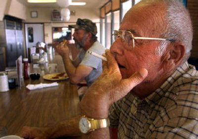 
James Lord, 65, of Dublin, Ga., smokes a cigarette at the counter at the Smoker's Cafe Tuesday, in Dublin Ga., while other customers eat lunch. Lord, a smoker for more than 50 years, said there is nothing like a cup of coffee and a cigarette. 
 (Associated Press / The Spokesman-Review)