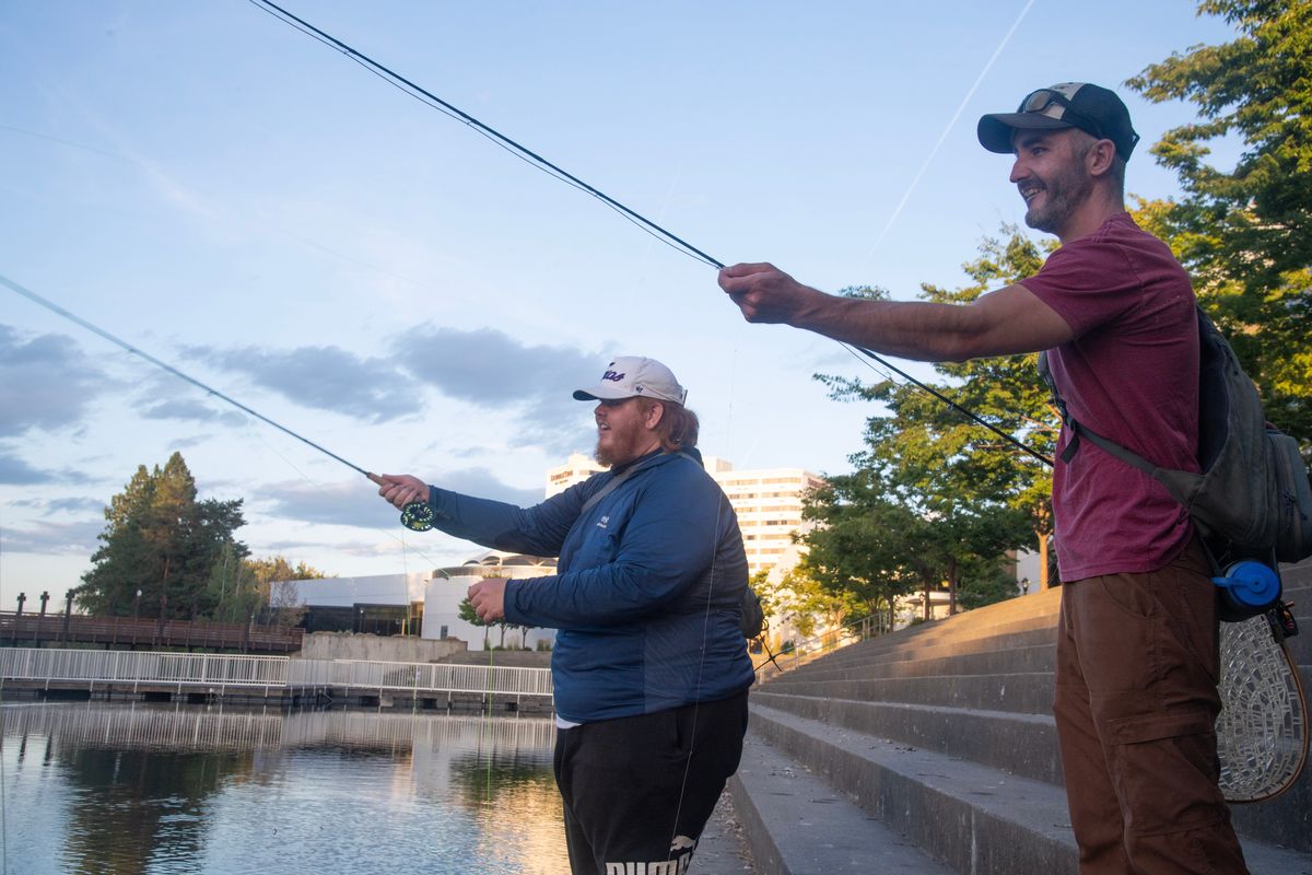 Marc Fryt, right and Noah Cecil toss in their lines on the steps of the Spokane Convention Center on the Spokane River on Aug. 8 at Riverfront Park. (Michael Wright/The Spokesman-Review)