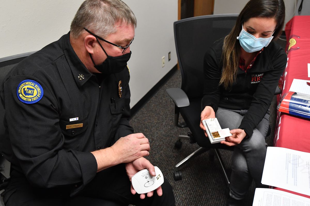 Spokane Fire Marshal Lance Dahl, left, and Jamie McIntyre, right, a community risk reduction manager, show differing carbon monoxide sensors Wednesday in Spokane.  (Tyler Tjomsland/The Spokesman-Review)