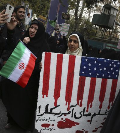 An Iranian demonstrator holds an anti-U.S. placard with writing in Persian which reads: 