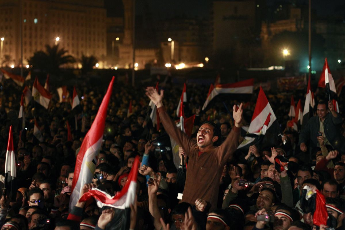 Egyptians celebrate the news of the resignation of President Hosni Mubarak, who handed control of the country to the military, at night in Tahrir Square in downtown Cairo, Egypt Friday, Feb. 11, 2011. (Ben Curtis / Associated Press)