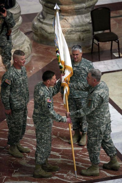 
 Gen.  David Petraeus, second from left, is handed a flag by a staff member for Gen. George Casey, second from right, as he takes over as top commander for U.S. troops in Iraq at a ceremony at Al Faw Palace at Camp Victory in Baghdad  on Saturday. 
 (Associated Press / The Spokesman-Review)