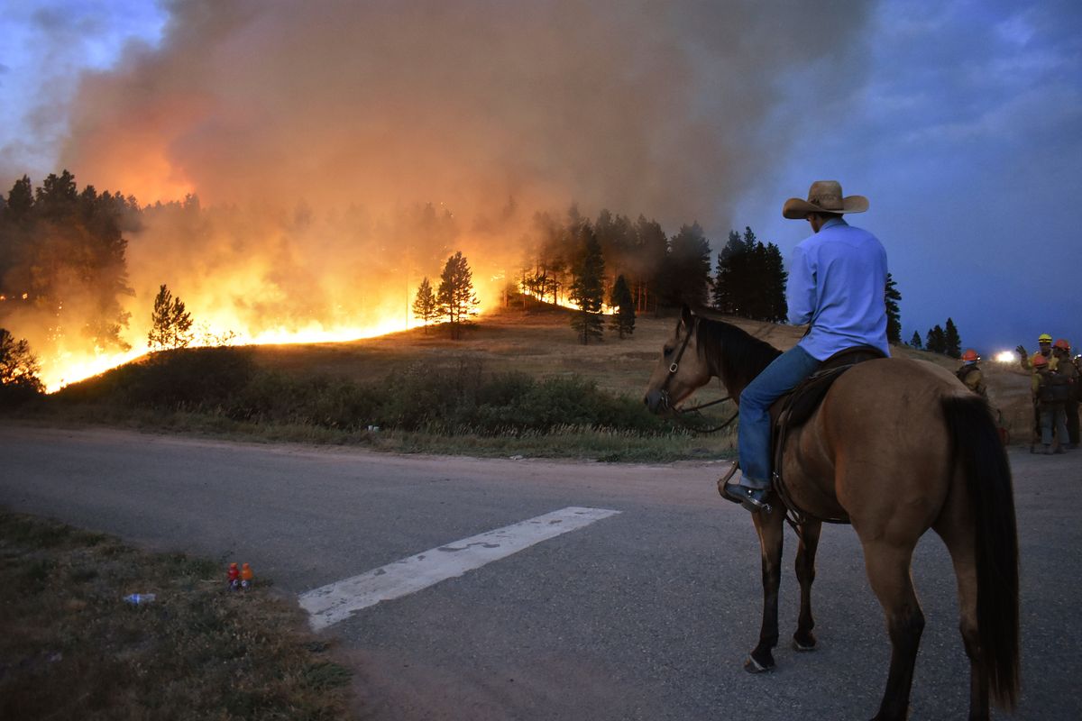 Rowdy Alexander watches from atop his horse as a hillside burns on the Northern Cheyenne Indian Reservation on Aug. 11 near Lame Deer, Mont.  (Matthew Brown)