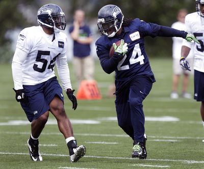 Rookie linebacker Bobby Wagner, left, closes in on running back Marshawn Lynch during practice. (Associated Press)