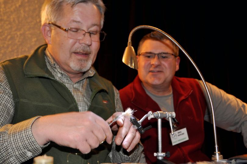 Mike Berube, right, watches Dan Ferguson tie his version of an October Caddis pattern. Both men are Spokane Fly Fishers members who contribute to the club's annual Fly Fishing School. (Rich Landers)