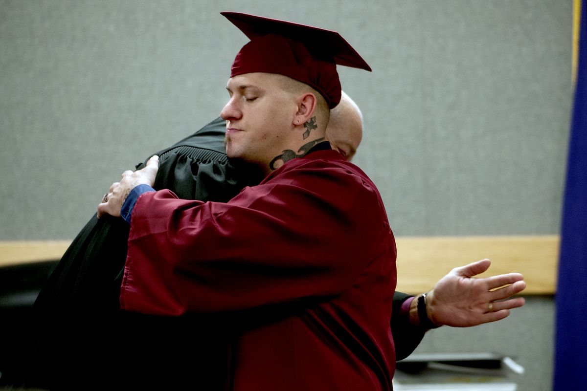 Kootenai County Mental Health Drug Court graduate Jordan Fox gets a hug from District Court Judge John Mitchell during a ceremony at the Justice Building in Coeur d’Alene on Thursday. The drug court is celebrating its 10th anniversary. (Kathy Plonka)