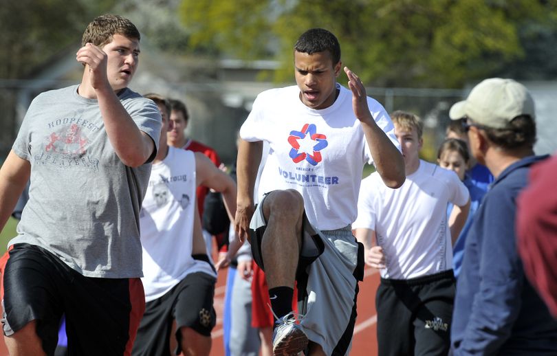 Carson Murray, center, warms up for practice at Rogers High School. Murray broke his own school record in the high jump Saturday, clearing 6 feet, 8 inches. (Jesse Tinsley)