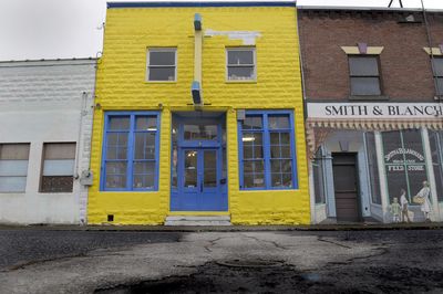 Tom Connelly operates a book store out of this brightly painted building at 3108 E. Olympic in Hillyard. The historic building has a working “Laundry” neon and paint sign hanging off the front.  (CHRISTOPHER ANDERSON / The Spokesman-Review)