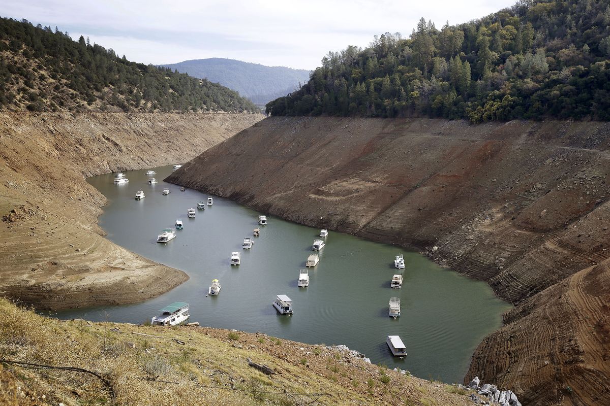 FILE - In this Oct. 30, 2014, file photo, houseboats float in the drought-lowered waters of Oroville Lake near Oroville, Calif. Rainstorms grew more erratic and droughts much longer across most of the U.S. West over the past half-century as climate change warmed the planet, according to a sweeping government study released, Tuesday, April 6, 2021, that concludes the situation in the region is worsening.  (Rich Pedroncelli)