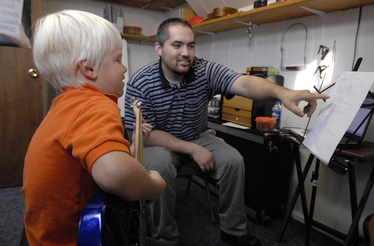 Carson Lueders, 7, works with his guitar teacher Spencer Ramos at the Creative Music Learning Center in Spokane Valley.  (J. BART RAYNIAK / The Spokesman-Review)