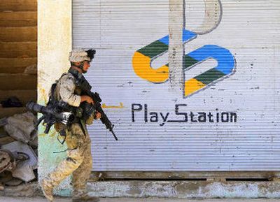 
U.S. Marine Lance Cpl. Anthony Weber walks past a shuttered storefront advertising the video game machine Play Station during a foot patrol in Hit, 125 miles west of Baghdad, on Friday. U.S. Marines conducting Operation Sword, now in its fourth day, are encouraging people to come out of their homes after completing searches earlier in the week. 
 (Associated Press / The Spokesman-Review)