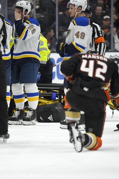 St. Louis Blues defenseman Vince Dunn, left, wipes his faces as Anaheim Ducks defenseman Josh Manson kneels on the ice while Blues defenseman Jay Bouwmeester, who suffered a medical emergency, is worked on by medical personnel during the first period of an NHL hockey game Tuesday, Feb. 11, 2020, in Anaheim, Calif. (Mark J. Terrill / Associated Press)