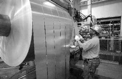 
An Alcoa employee inspects finished rolls of aluminum as they come off the last stage of the production line in this at the Alcoa Warrick Operations in Newburgh, Ind. 
 (Associated Press / The Spokesman-Review)