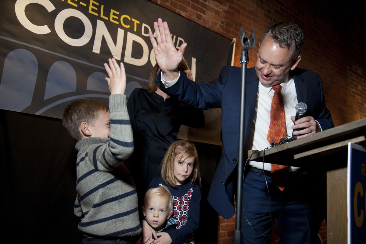 Mayor David Condon celebrates his re-election with a high-five to his son Creighton after getting results, Nov. 3, 2015, at Barrister Winery in downtown Spokane, Wash. His other children are Beck and Hattie. (Dan Pelle / The Spokesman-Review)