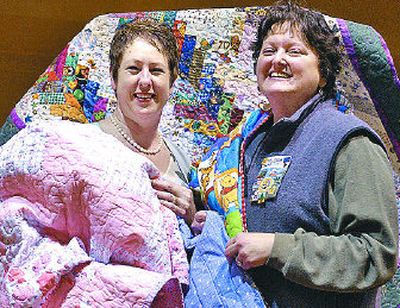 
Deanna Griffith, left, and BeLinda  Labounty show off quilts to be donated to the Vanessa Behan Crisis Nursery.
 (J. BART RAYNIAK / The Spokesman-Review)