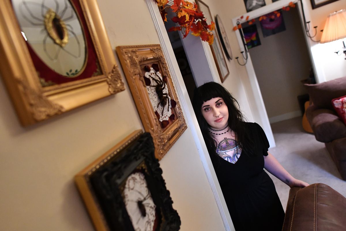 CarLy Haney, 27, poses for a photo with some of her spider-based art on Thursday, Oct. 11, 2018, in her home in Spokane, Wash. (Tyler Tjomsland / The Spokesman-Review)