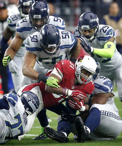 K.J Wright (50) and Seattle’s top-rated defense, here putting the clamps on Arizona running back David Johnson, will be tested by Atlanta’s top-rated offense Sunday in Seattle. (Rick Scuteri / Associated Press)