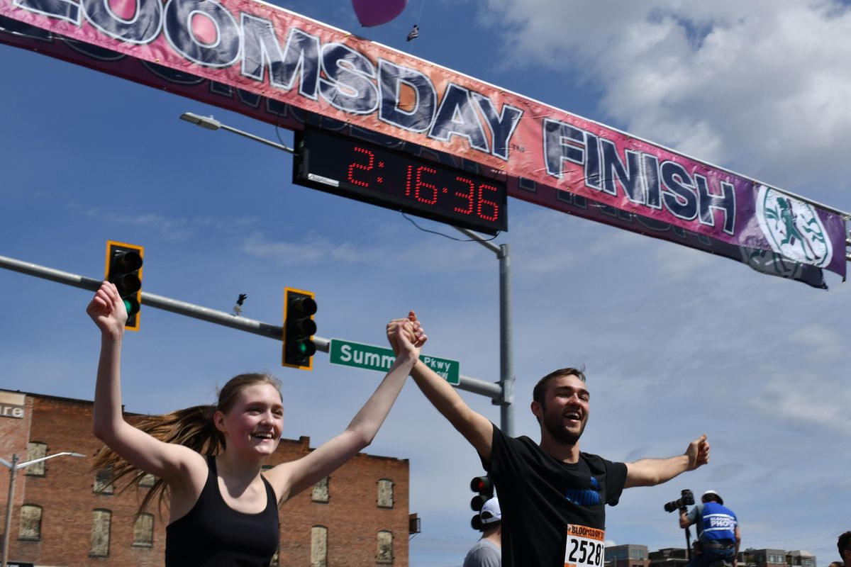 Julia Denisiuk and Erik Denisiuk holds hands as they cross the finish line during Bloomsday 2019 on Sunday, May 5, 2019 in Spokane, Wash. (Tyler Tjomsland / The Spokesman-Review)