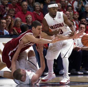 WSU's Klay Thompson struggles to pass through the defense of Arizona's Zane Johnson, on floor, and Nic Wise. (Associated Press)